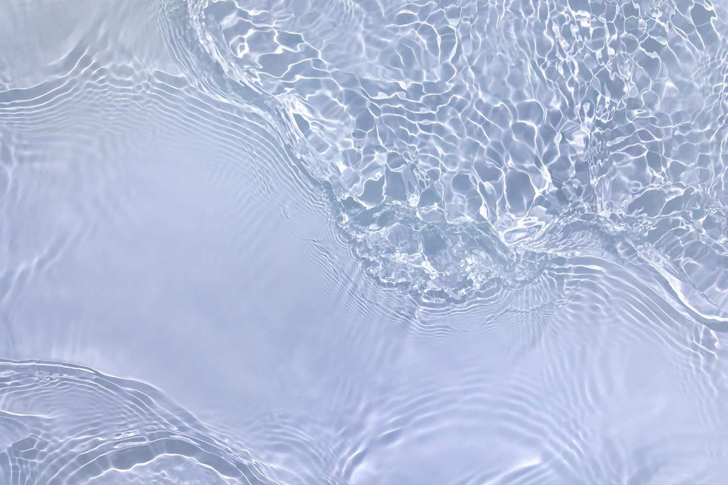 Ljus pastellblå transparent klar vattenytestruktur med krusningar, stänk och vågor i solljus